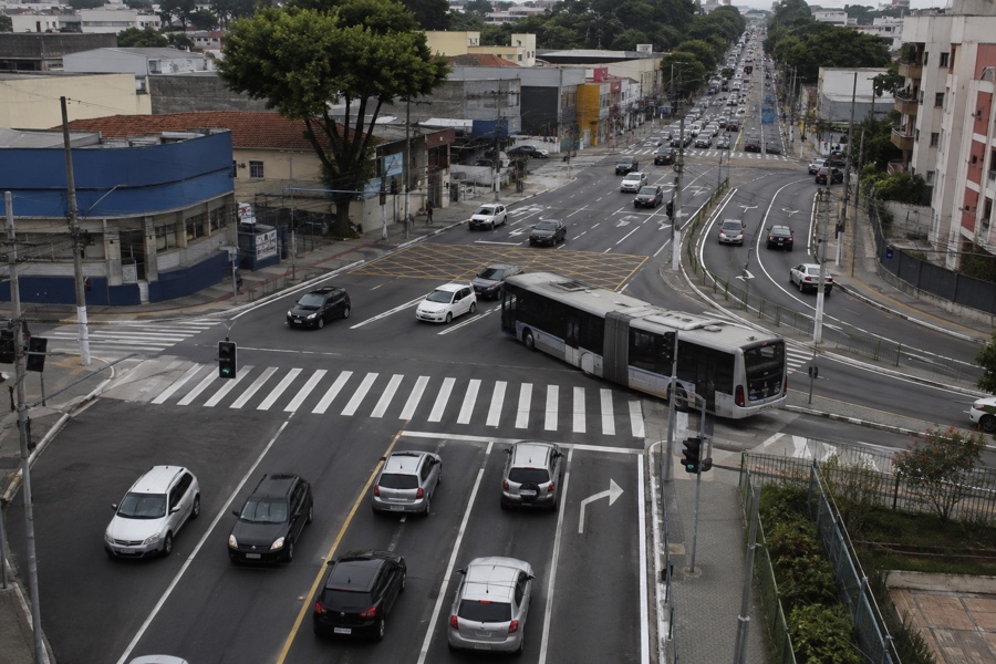 Cruzamento urbano com faixas de circulação ampliadas e ônibus