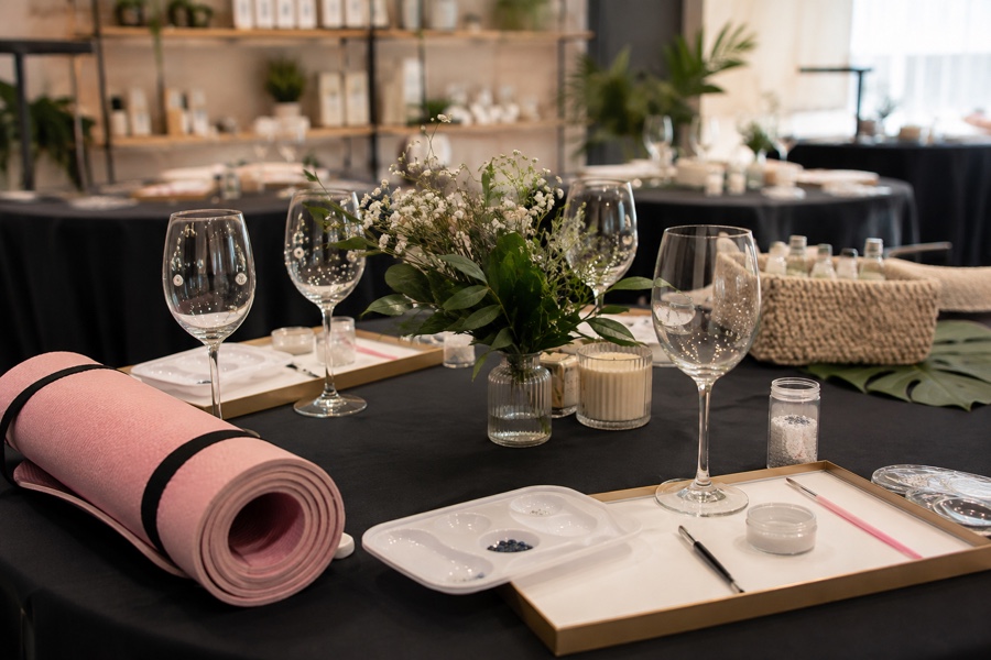 Mesa de evento com materiais de customização, bem-estar e exposição de produtos