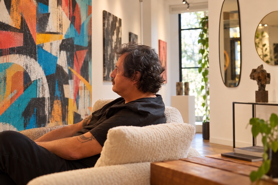 Retrato editorial de Douglas Ferreira em galeria com arte urbana