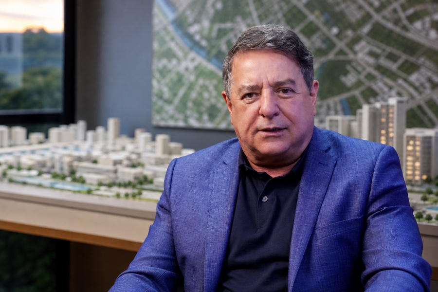 Nilson Colombo em ambiente de planejamento imobiliário com maquete urbana ao fundo